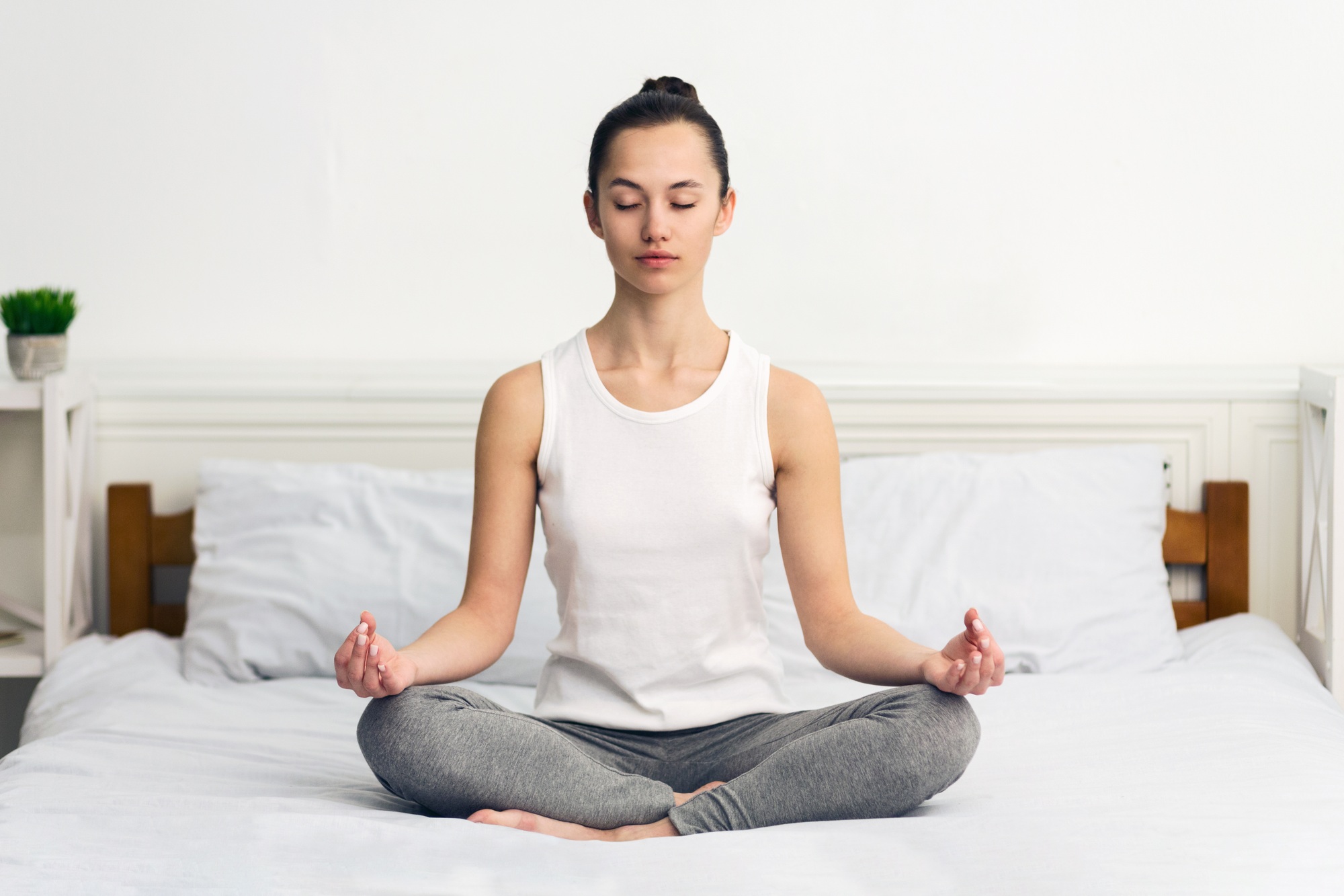 Woman Meditating on Bed in Morning Light